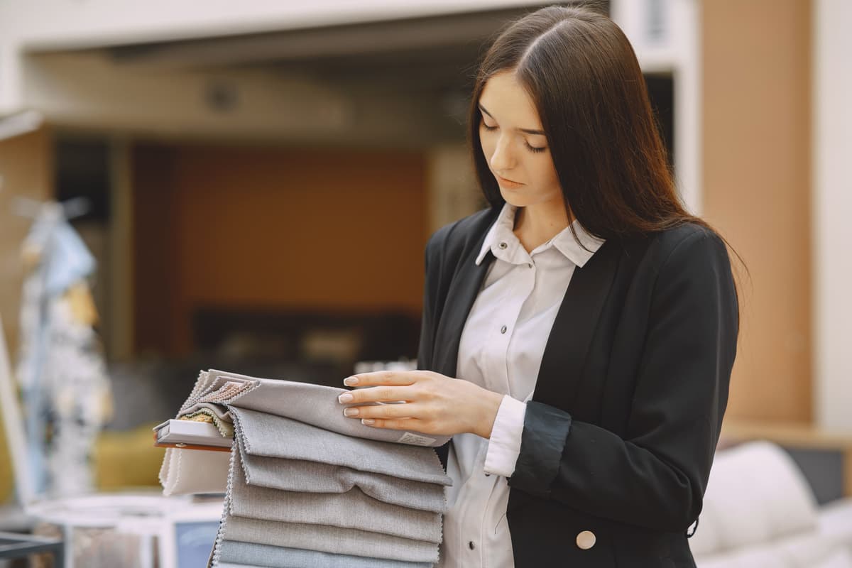 laundry worker checking fabric type of garment before washing in shop